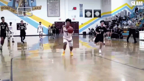 A Basketball Game Is Being Played In A Gym With The Word Slam On The Wall GIF