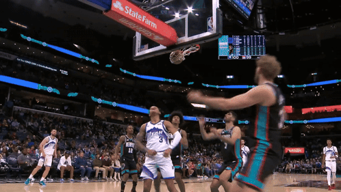 A Basketball Game Is Being Played In A Stadium With A State Farm Banner On The Hoop GIF