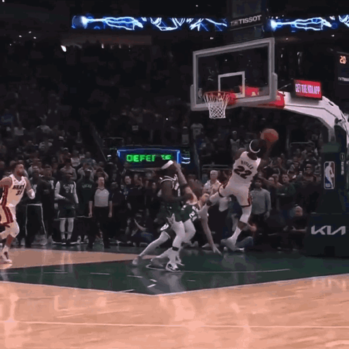 a basketball game is being played in front of a crowd and a sign that says defer