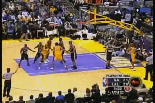 A Basketball Game Is Being Played In Front Of A Crowd Of People . GIF