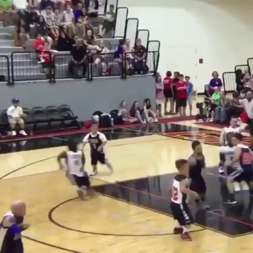 A Basketball Game Is Being Played In Front Of A Crowd Of People GIF