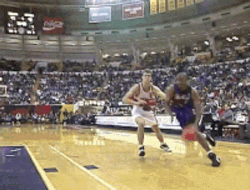 A Basketball Game Is Being Played In Front Of A Crowd With A Coca Cola Sign In The Background GIF