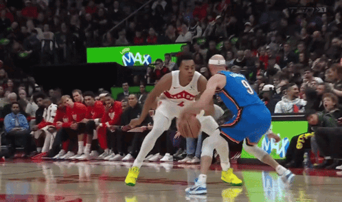 a basketball game is being played in front of a crowd with a max advertisement in the background