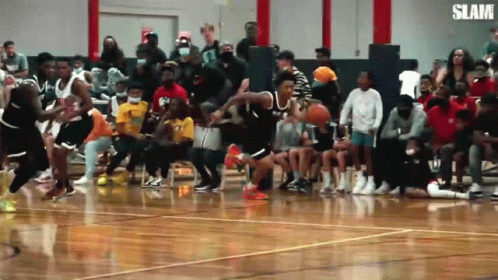 A Basketball Game Is Being Played In Front Of A Crowd With The Word Slam On The Bottom Right GIF