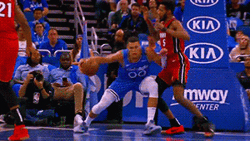 A Basketball Game Is Being Played In Front Of A Kia Advertisement . GIF