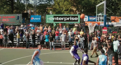 a basketball game is being played in front of a large crowd and a banner that says enterprise