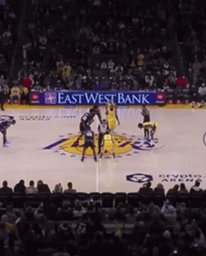 a basketball game is being played in front of an east west bank ad