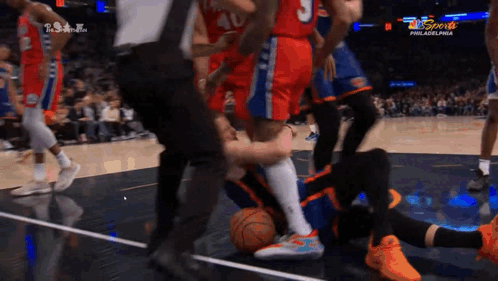 a basketball game is being played in philadelphia and a player is laying on the floor