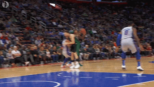 A Basketball Game Is Being Played On A Court With A Crowd In The Stands . GIF