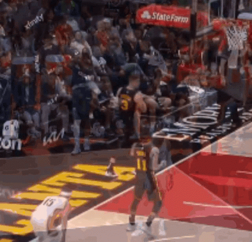 A Basketball Game Is Being Played On A Court With A Crowd In The Stands . GIF