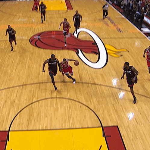 A Basketball Game Is Being Played On A Court With A Logo For The Heat On It GIF