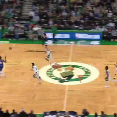 a basketball game is being played on a court with the celtics logo in the middle