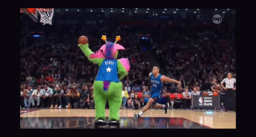 A Basketball Game Is Being Played With A Mascot Wearing A Purple And Blue Outfit With A Star On The Back GIF