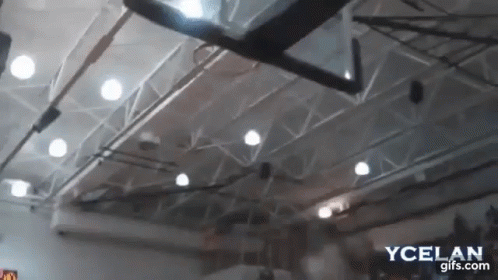 A Basketball Hoop Is Hanging From The Ceiling Of A Gymnasium GIF