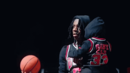 A Basketball Is Going Through A Basketball Hoop In A Gym . GIF