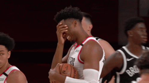 a basketball player covering his face while holding the ball