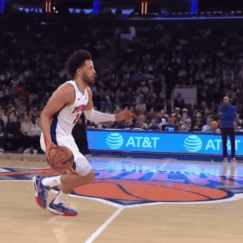 A Basketball Player Dribbles A Basketball On A Court With An At & T Ad In The Background GIF