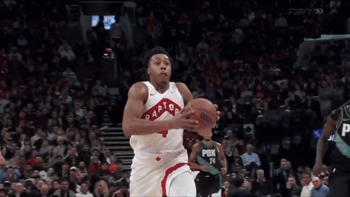 a basketball player for the raptors is dribbling a basketball