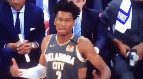 A Basketball Player From Oklahoma City Is Giving A Thumbs Up While Sitting In The Stands During A Game . GIF