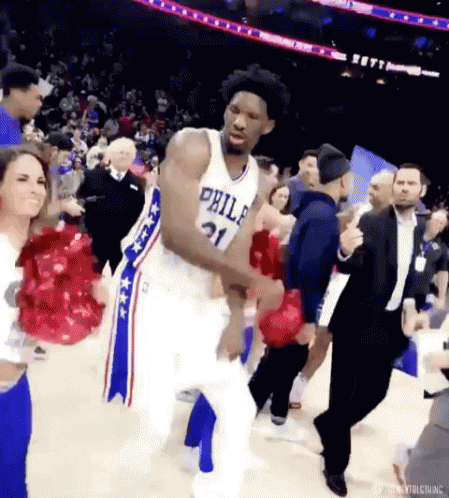 A Basketball Player From The Philadelphia 76Ers Is Dancing On The Court With Fans . GIF
