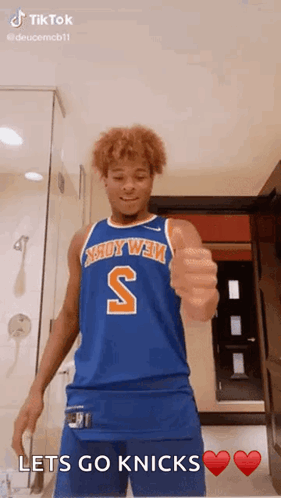 A Basketball Player In A Blue Jersey Is Giving A Thumbs Up Sign . GIF