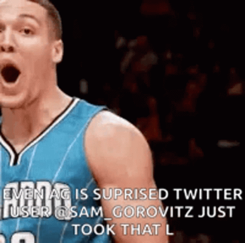 A Basketball Player In A Blue Jersey Is Making A Funny Face While Standing On The Court . GIF