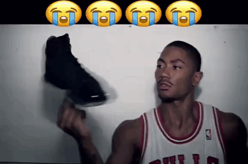 A Basketball Player In A Bulls Jersey Is Holding A Shoe GIF
