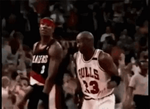 A Basketball Player In A Bulls Jersey Is Running Towards Another Player . GIF