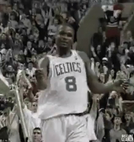 A Basketball Player In A Celtics Jersey Is Dancing In Front Of A Crowd Of People . GIF