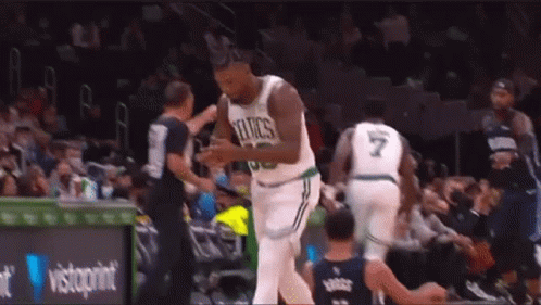 A Basketball Player In A Celtics Jersey Is Talking To A Referee During A Basketball Game . GIF