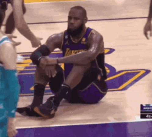 A Basketball Player In A Lakers Jersey Sits On The Floor GIF