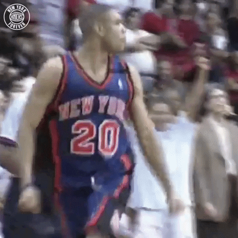 A Basketball Player In A New York Knicks Jersey Is Standing In Front Of A Crowd . GIF