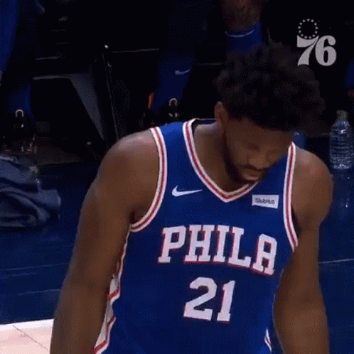 A Basketball Player In A Philadelphia 76Ers Jersey Is Standing On A Court . GIF