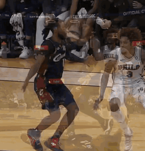 a basketball player in a philadelphia jersey is dribbling the ball