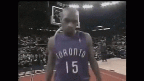 A Basketball Player In A Purple Jersey With The Number 15 On It Is Standing On A Court . GIF