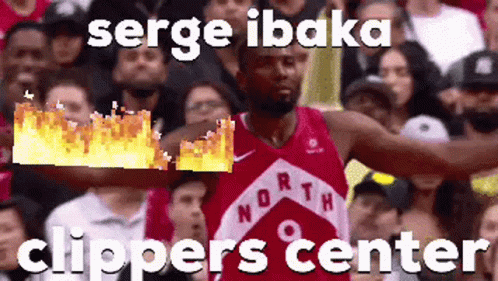 A Basketball Player In A Red Jersey Is Holding A Fireball In His Hand In Front Of A Crowd Of People . GIF