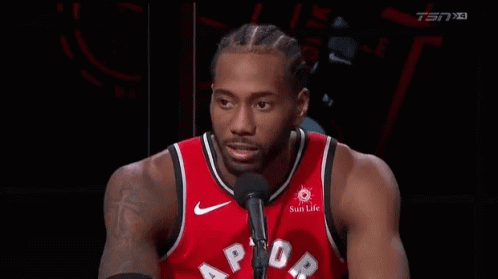 A Basketball Player In A Red Jersey Is Talking Into A Microphone . GIF