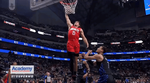 A Basketball Player In A Red Rockets Jersey Dribbles The Ball GIF