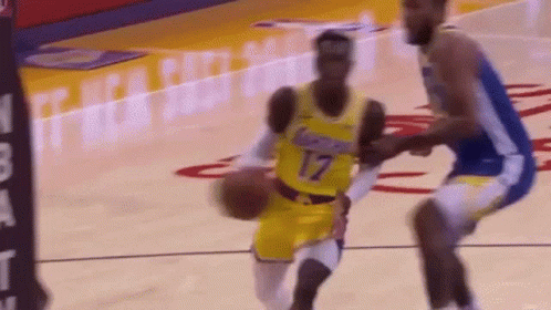 A Basketball Player In A Yellow Jersey Is Dribbling The Ball While Another Player In A Blue Jersey Tries To Stop Him . GIF