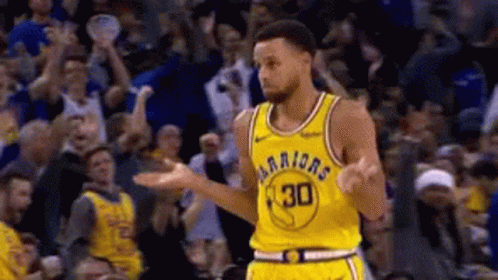 A Basketball Player In A Yellow Jersey With The Number 30 On It Is Standing In Front Of A Crowd Of People . GIF