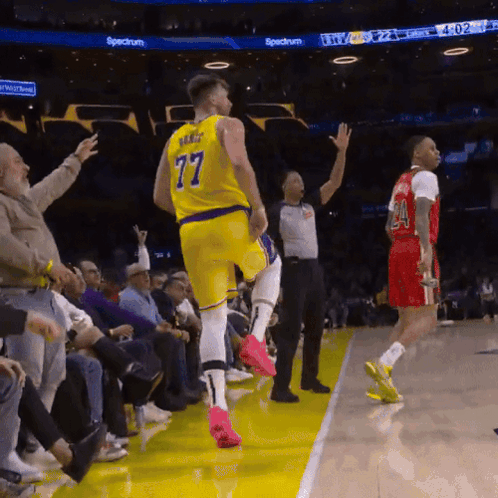 A Basketball Player In A Yellow Jersey With The Number 77 On The Back GIF
