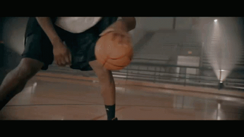 A Basketball Player Is Dribbling A Ball On A Court GIF