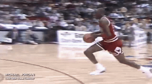A Basketball Player Is Dribbling A Basketball On A Court . GIF