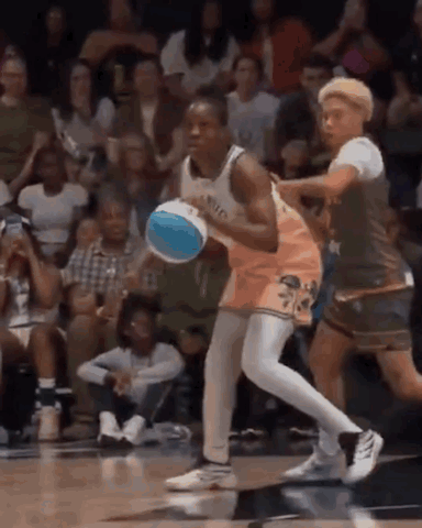 A Basketball Player Is Dribbling A Basketball While Another Player Tries To Stop Him . GIF