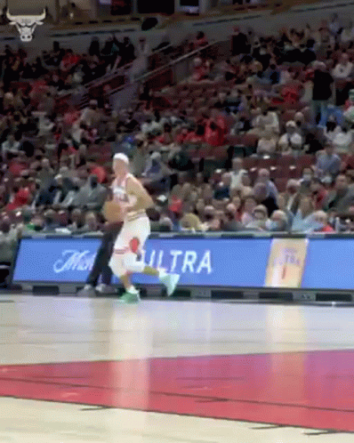 A Basketball Player Is Dribbling The Ball On A Basketball Court . GIF