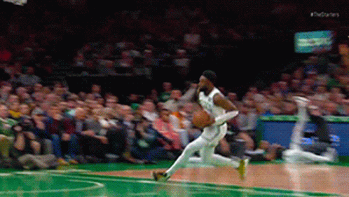 A Basketball Player Is Dribbling The Ball On A Court With A Crowd Watching GIF