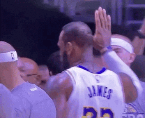 A Basketball Player Is Giving A High Five To His Teammate . GIF