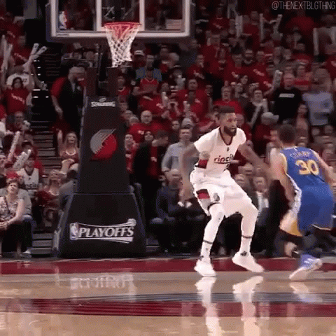 A Basketball Player Is Jumping In The Air In Front Of A Crowd During A Playoff Game . GIF