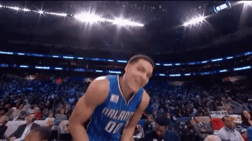 A Basketball Player Is Jumping In The Air In Front Of A Crowd . GIF