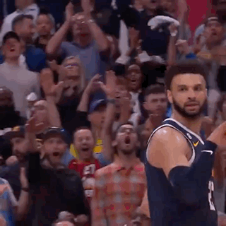 A Basketball Player Is Jumping In The Air In Front Of A Crowd Of People . GIF